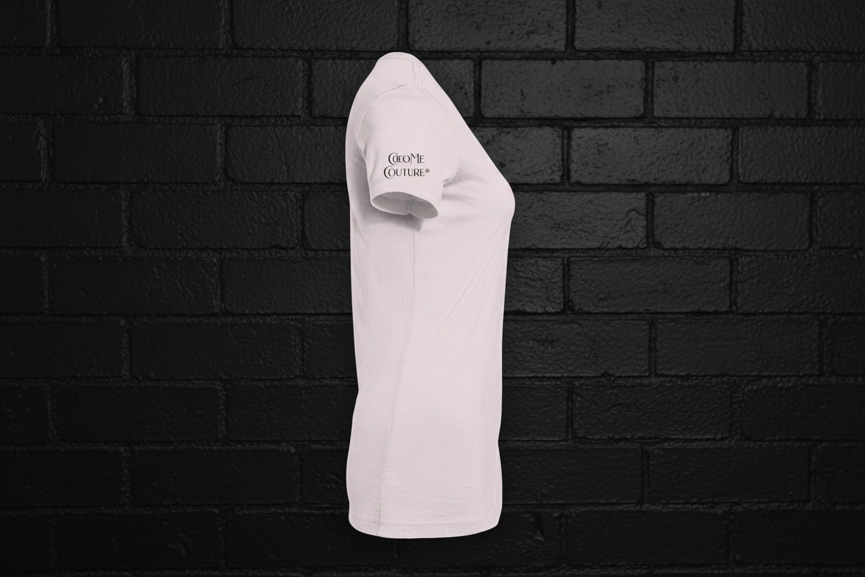 Side view of a white women's slim fit cotton graphic tee with a small sleeve logo against a black brick wall background.