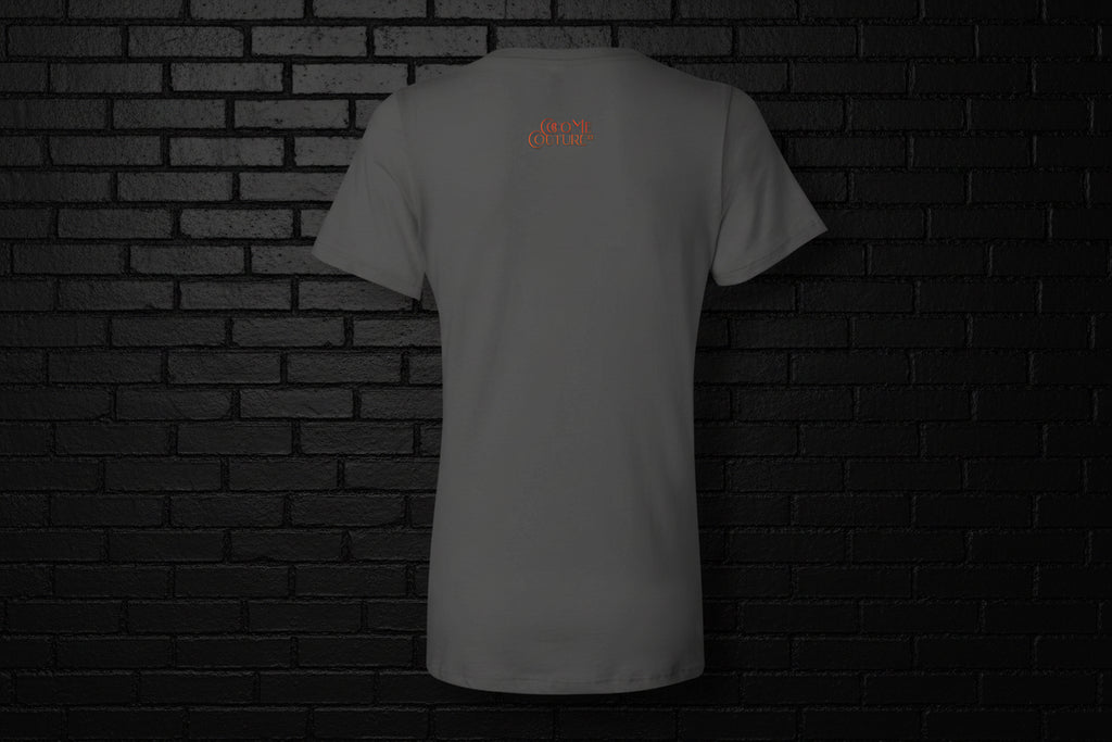 Back view of the grey Unbothered Vibe women's graphic v-neck tee featuring a small orange logo on a dark brick background.