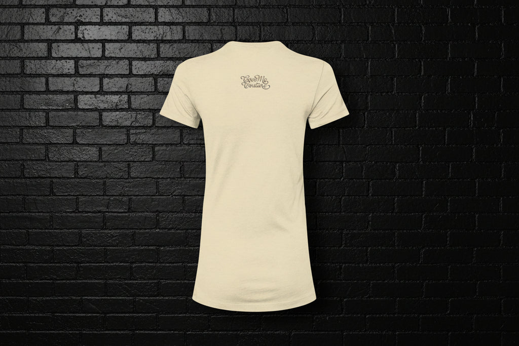 Back view of the Breathe Luxury Slim Fit Tee in cream featuring the Cocome Couture logo on a black brick background.