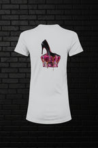 White Royal Rebellion graphic tee with a black stiletto on a molten pink and gold crown against a dark brick wall.