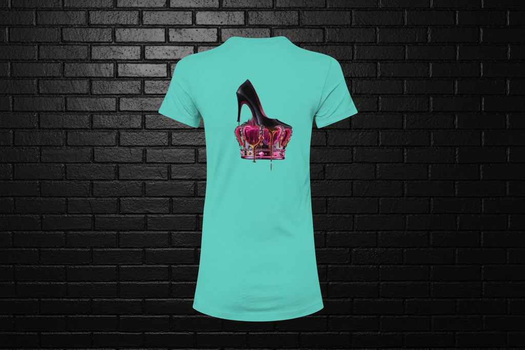 Royal Rebellion Graphic Tee in teal featuring a black stiletto on a molten pink and gold crown, shown against a brick wall.
