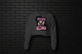 Rule Loud Women's Crop Hoodie in Charcoal with crown and stiletto heel graphic on a black brick background.