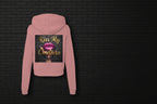 Back view of mauve Kiss My Couture Luxe Streetwear hoodie with pink lips graphic against a black brick wall background.