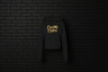 Black CocoMe Couture fleece hoodie with gold dripping logo on a dark brick background — luxe streetwear front view.
