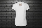 Back view of the Soft but Dangerous Performance Tee in white with Cocome Couture logo on a black brick background.
