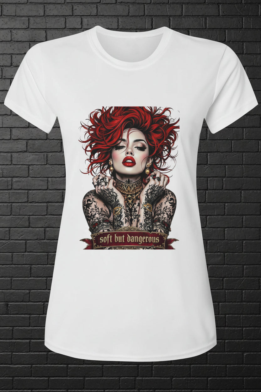 White women's activewear tee with 'Soft but Dangerous' graphic featuring a red-haired woman with tattoos.