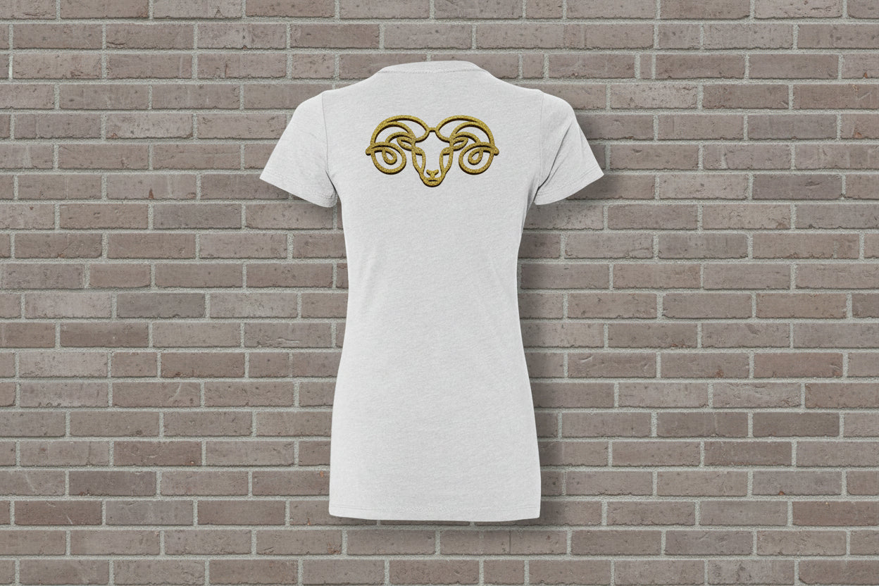 Back view of Aries the Ram Premium Tee in white with a gold zodiac astrology graphic on a brick wall background.