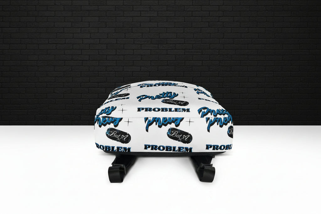 Bottom view of Pretty But A Problem water-resistant laptop backpack with white graphic print and black straps.