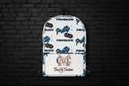 White Pretty But A Problem laptop backpack with blue graphic text and Cocome Couture logo against a black brick wall.