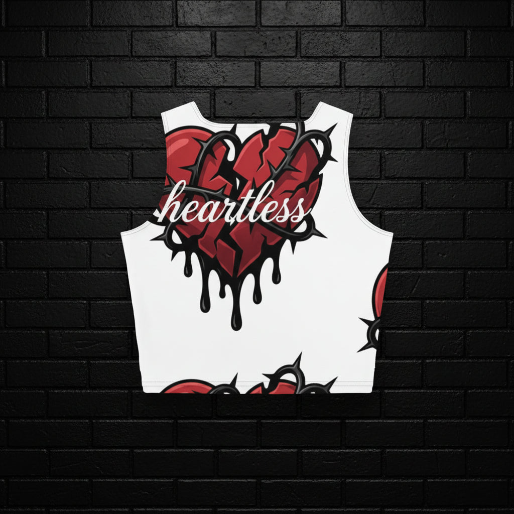 Women's Heartless Crop Top with broken heart and barbed wire streetwear print, white ribbed activewear against brick wall.