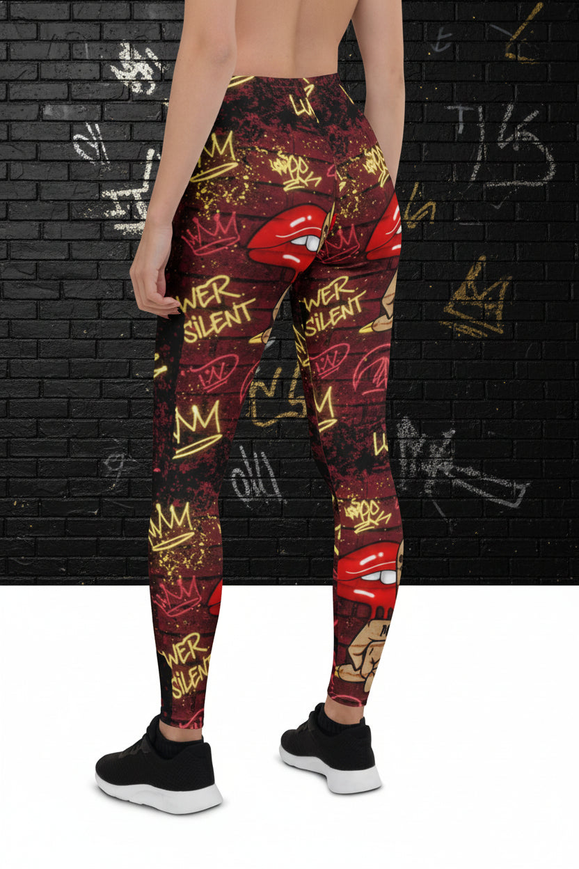 Queens Move In Silence high-waisted leggings with red lips and graffiti crown print on a dark brick background.