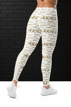 Rear view of white high waisted yoga leggings with a gold Aries all-over print pattern, paired with white sneakers.