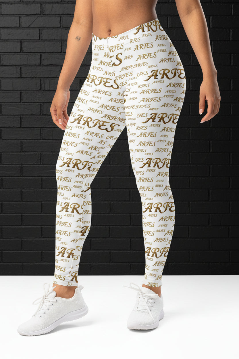 High waisted white yoga leggings with gold Aries zodiac print on model standing against a dark brick background.