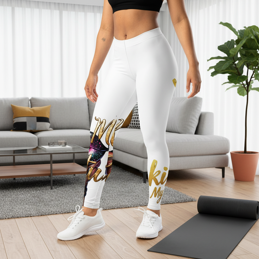 Person wearing white leggings with gold text in a living room setting